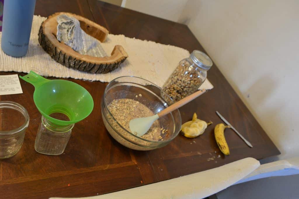 overnight oats ingredients mixing in glass bowl on kitchen table