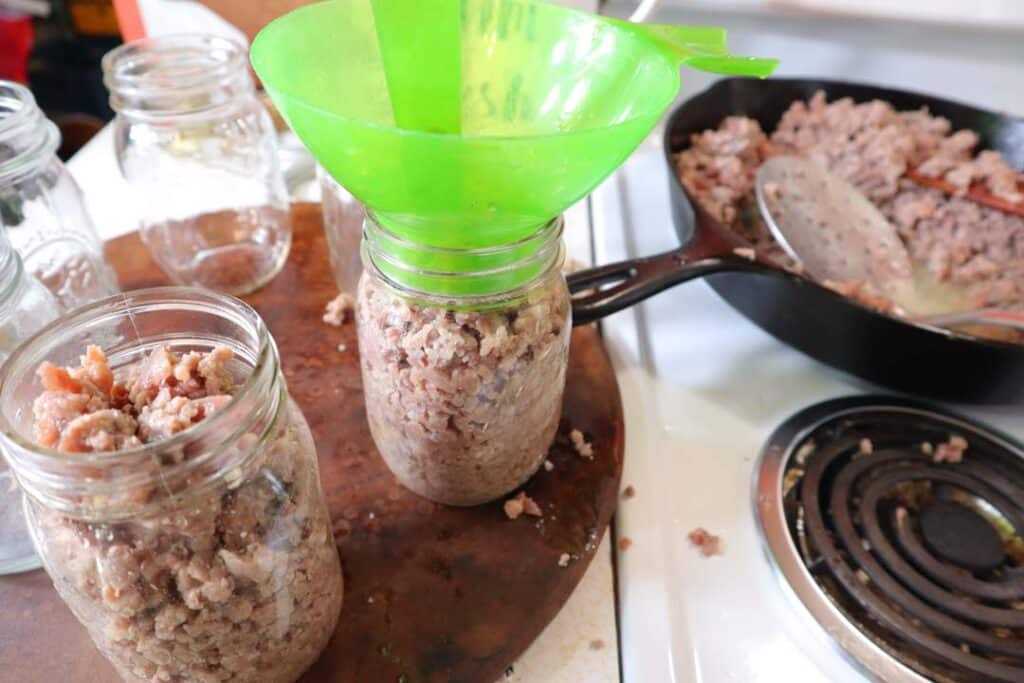 adding sausage to canning jars