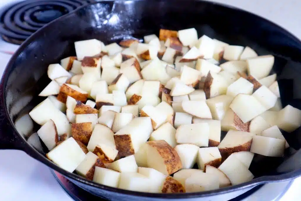 raw potatoes in cast iron skillet