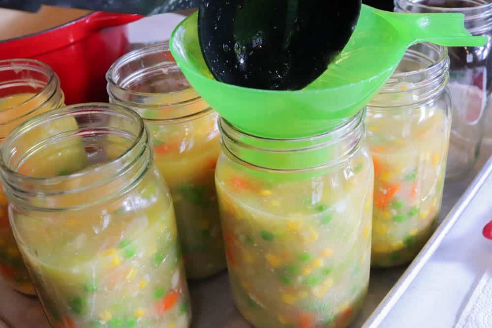 ladle in mason jars with chicken pot pie filling