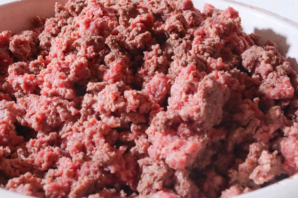 half cooked ground beef in white bowl
